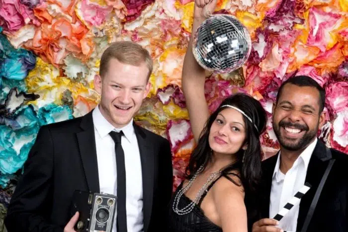 DIY photo booth with colorful paper flowers and party props