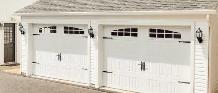 Two white single-car carriage doors with windows