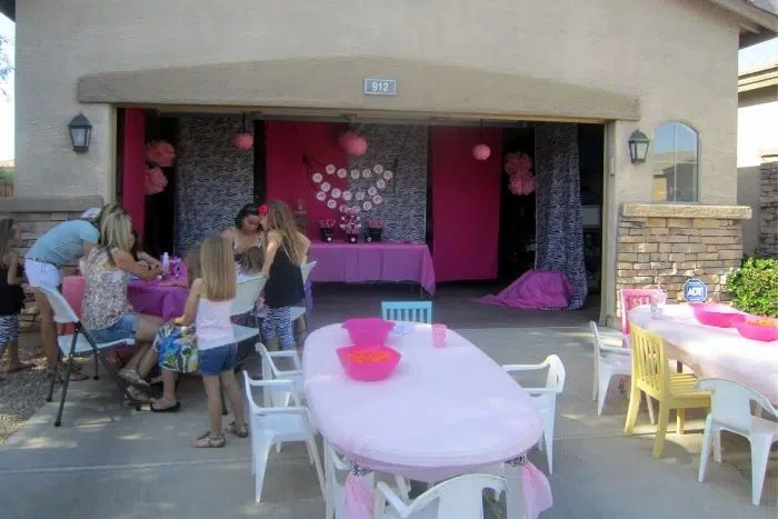 Pink birthday party extending from a garage onto the driveway