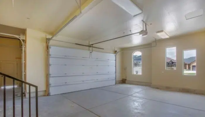 Tan garage walls with a white garage door and windows