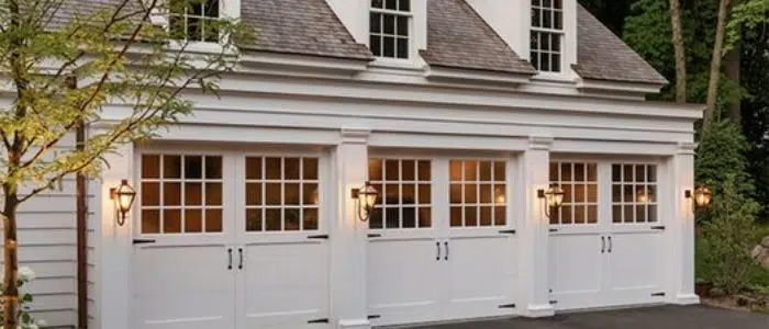 Three white carriage-style garage doors with windows