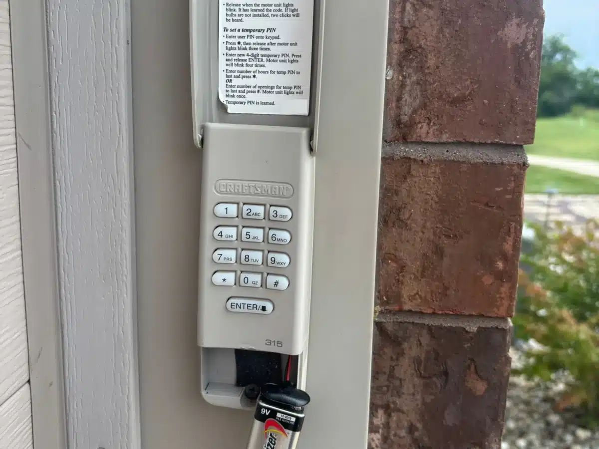 Open garage door keypad showing its 9V battery and battery compartment